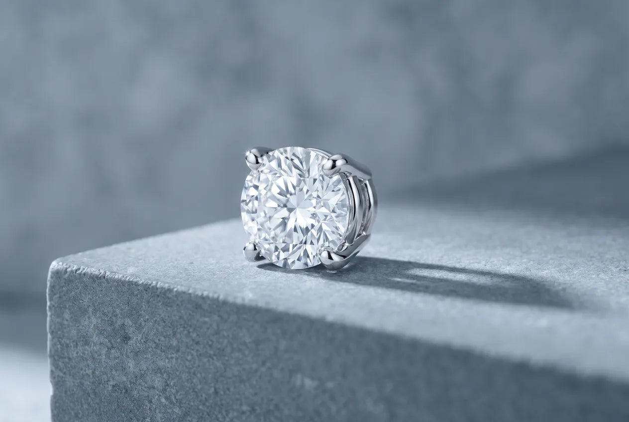 A round diamond held by four white gold prongs gripping its girdle