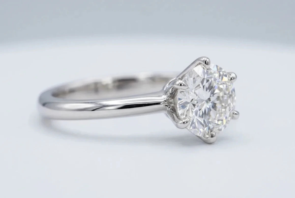 Macro close-up of a six-prong white gold solitaire setting holding a round diamond