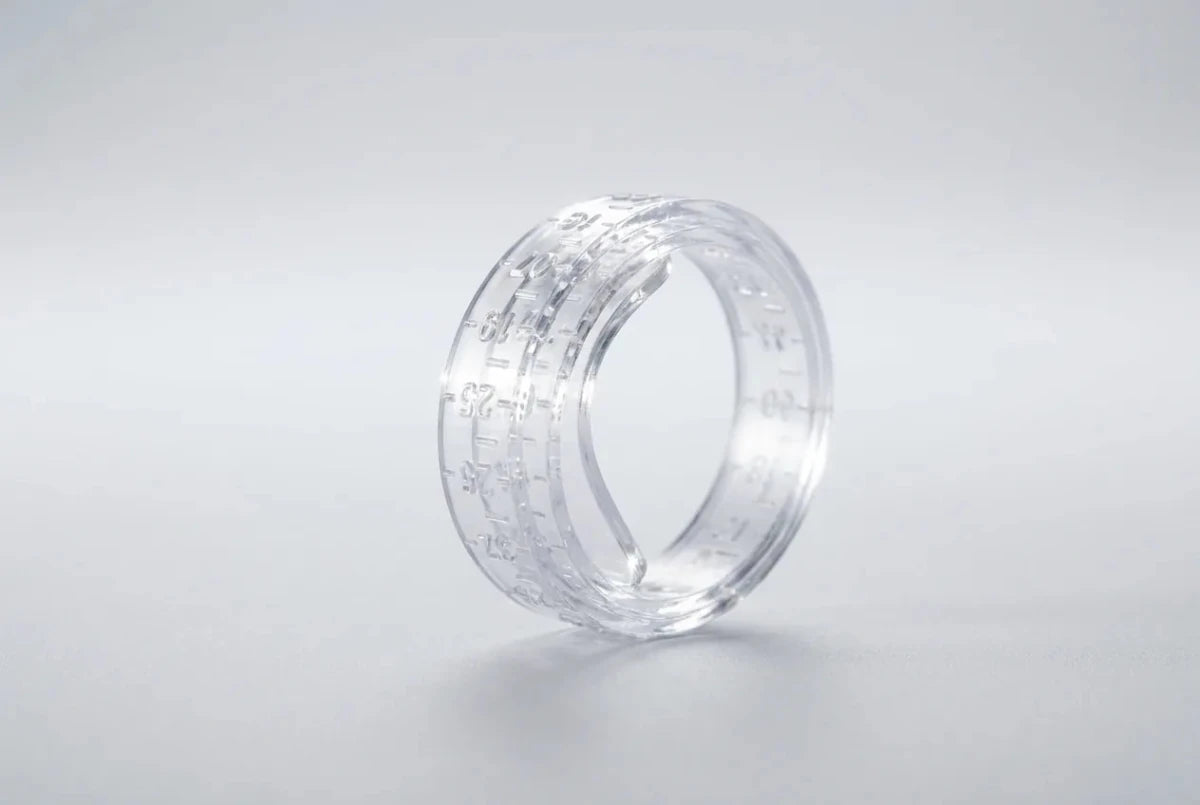 A clear plastic ring sizer gauge fastened like a belt into a ring shape