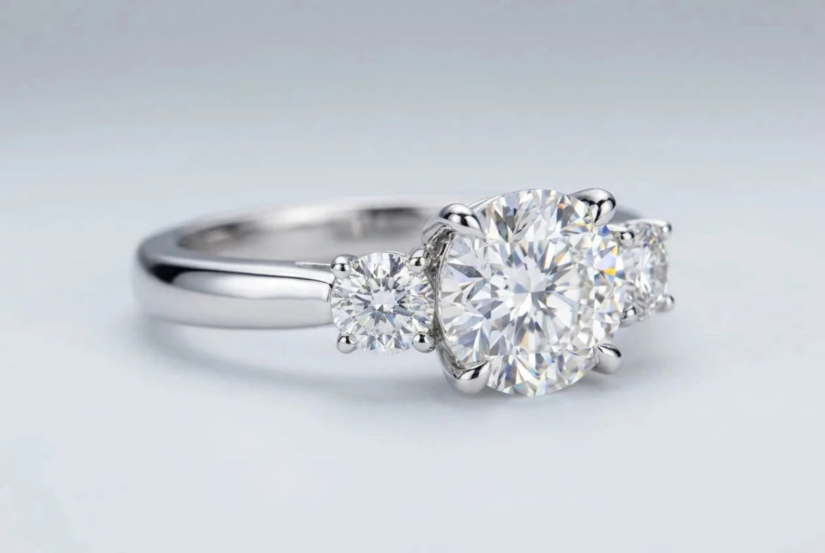 Three-stone ring with a center diamond flanked by two smaller diamonds