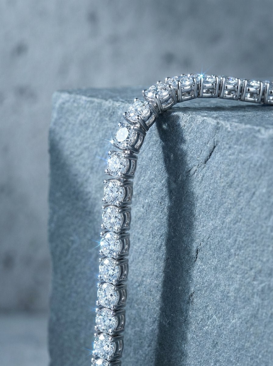 A diamond tennis bracelet draped over the edge of a gray stone block