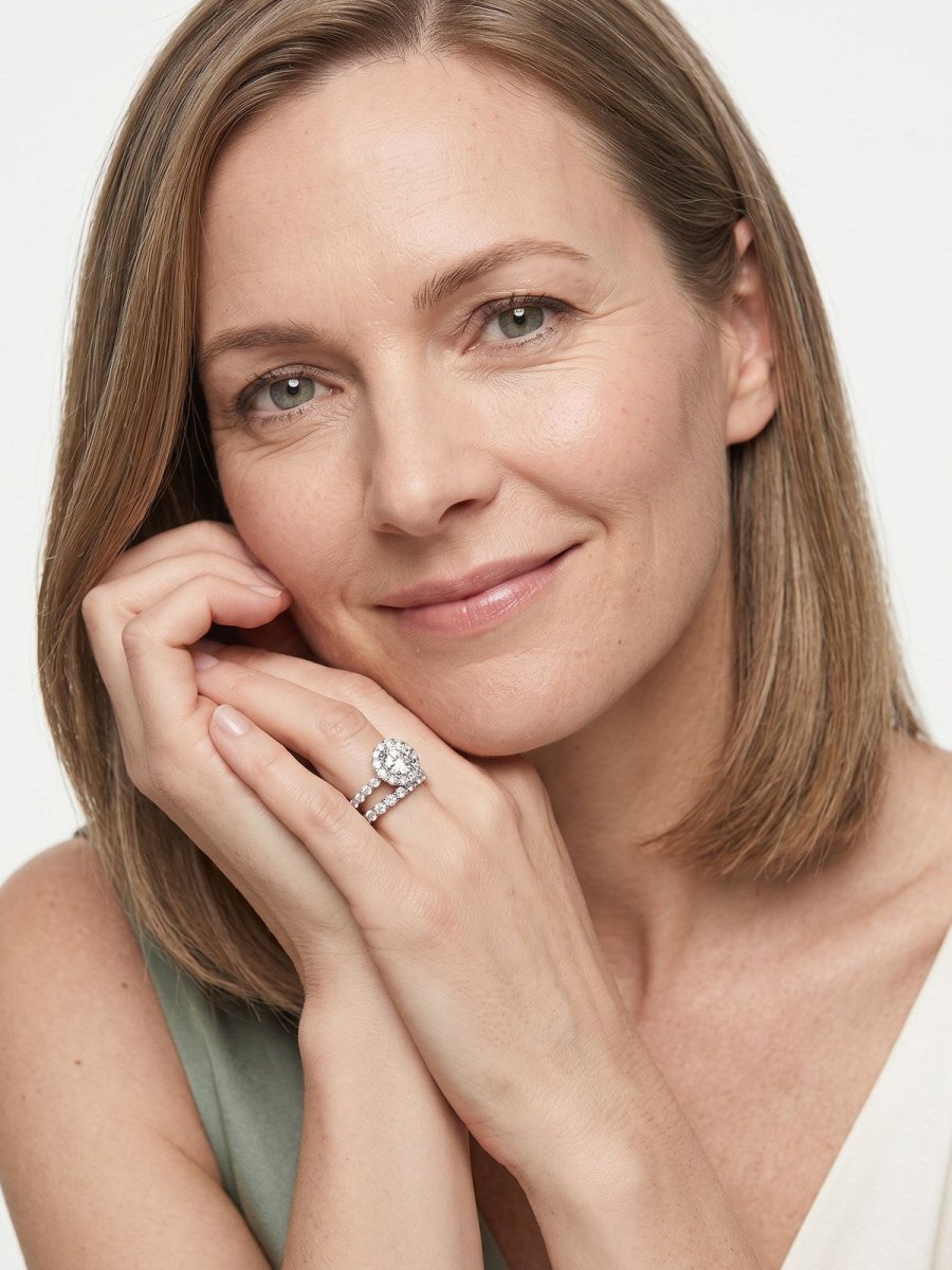 Model B in sage, hands together, wearing a diamond engagement ring with its matching wedding band