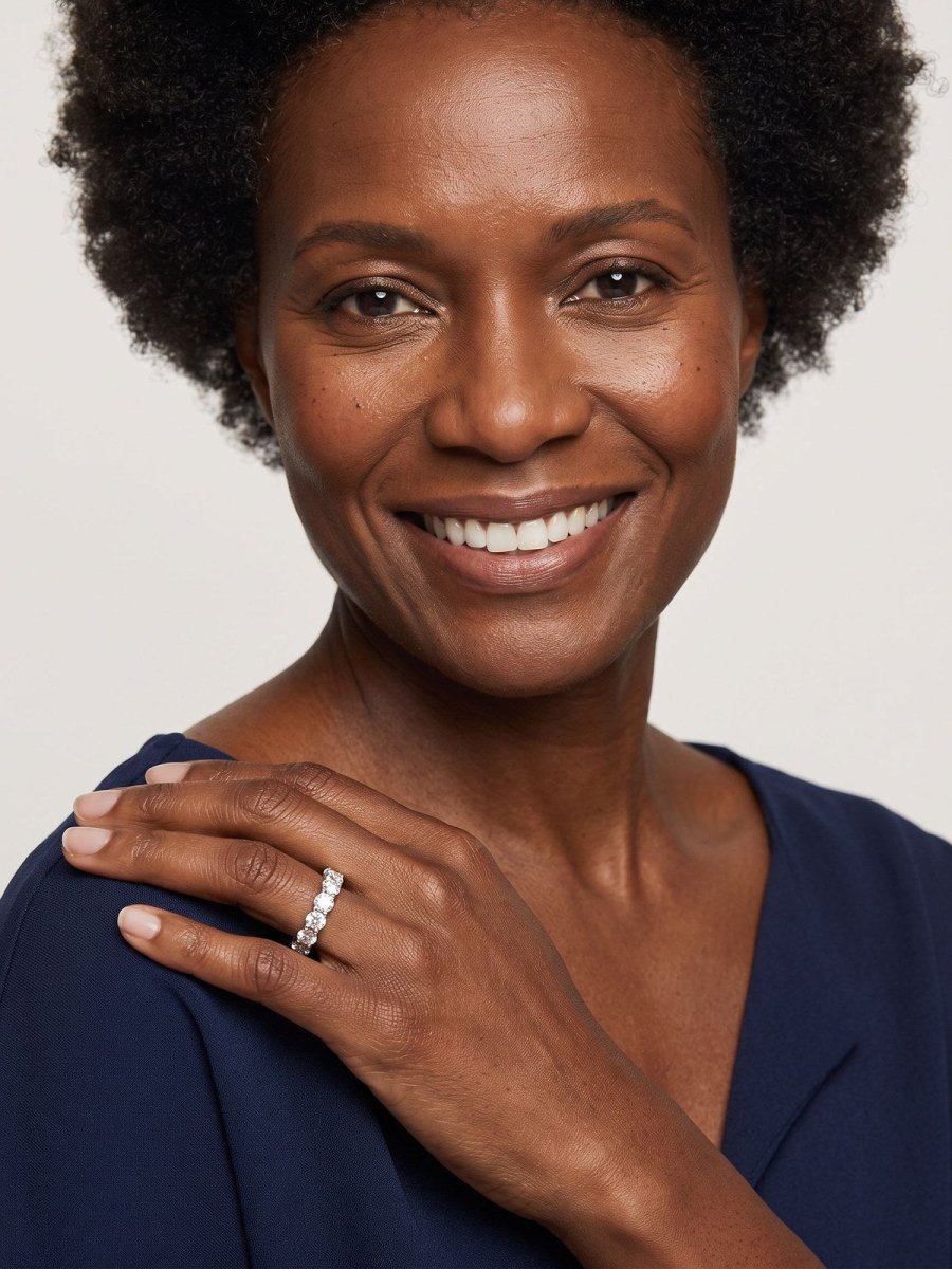 Model C in navy, hand resting on her shoulder, wearing a diamond eternity wedding band