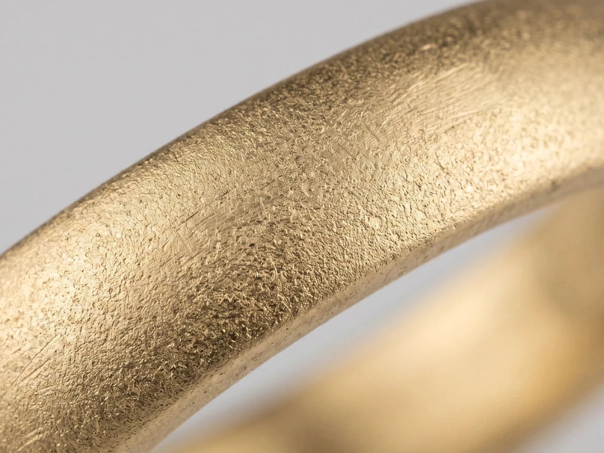 Macro close-up of an unfinished cast ring shank, surface still rough before setting and polishing