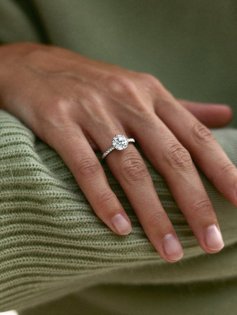 Solitaire diamond engagement ring worn on a hand