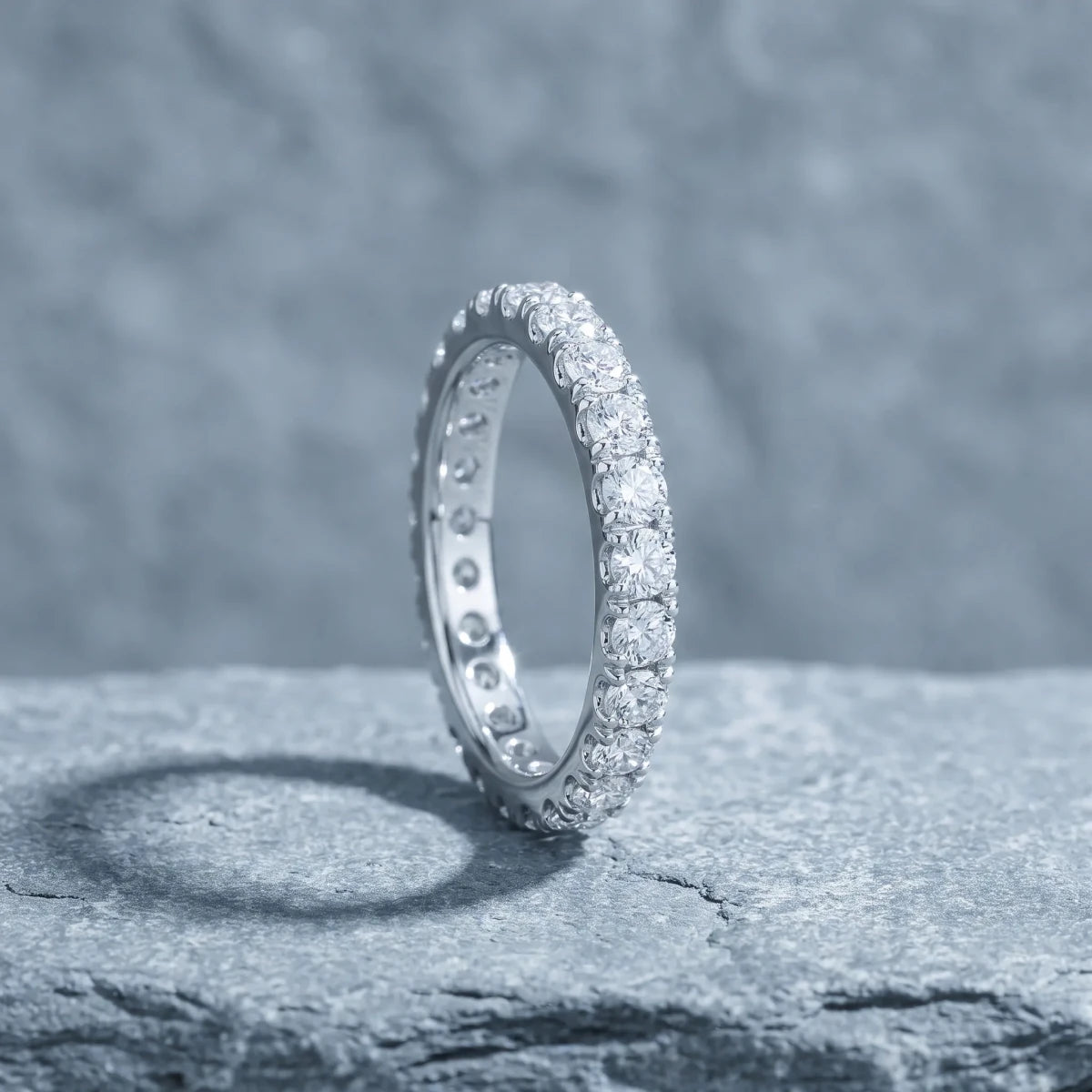 A diamond eternity band standing on a stone plinth