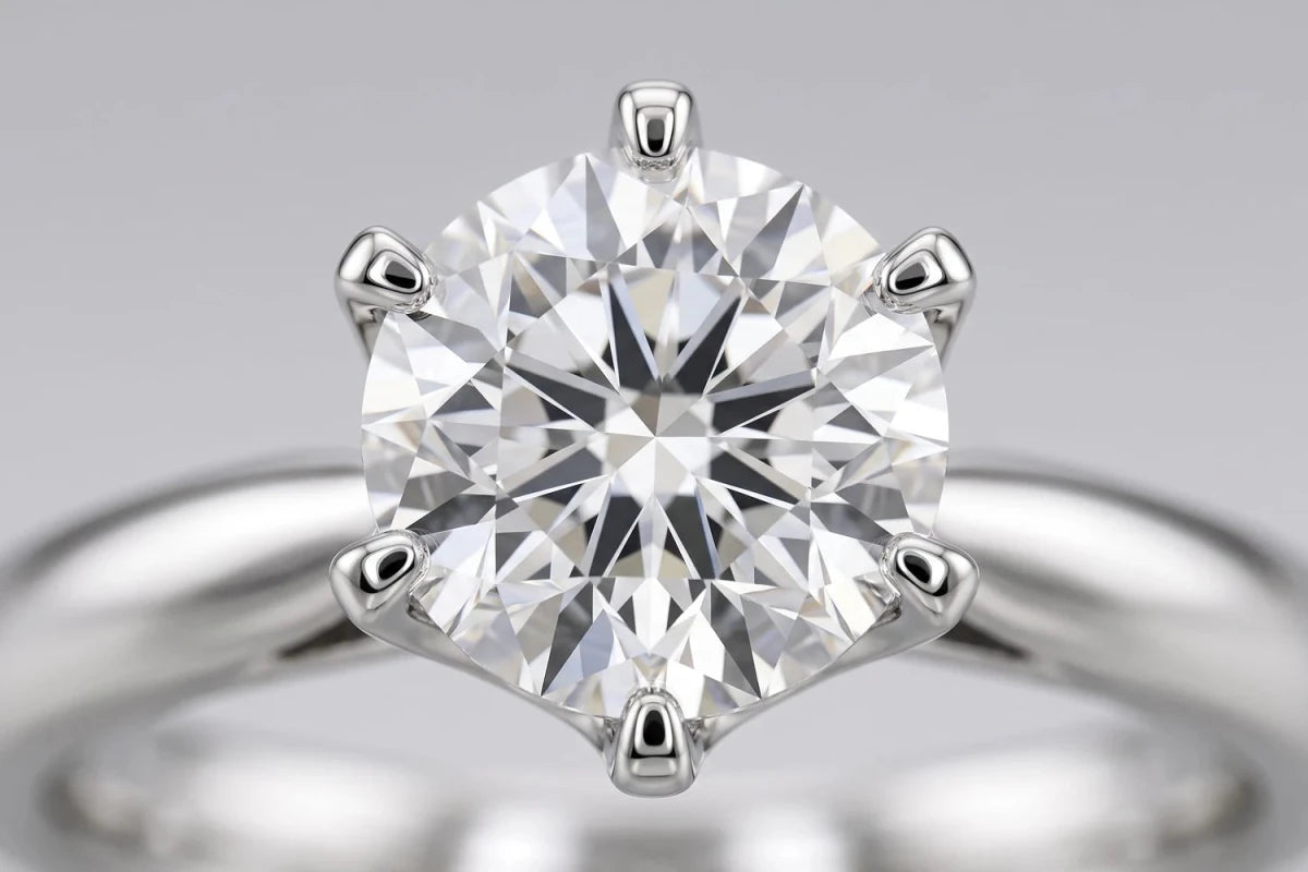 Macro close-up of a round diamond seated in its prongs, the prong tips closed over the stone