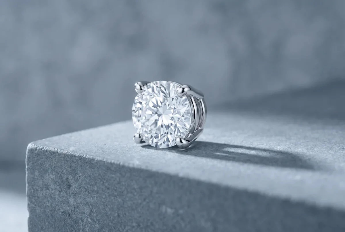 A round diamond held by four white gold prongs gripping its girdle