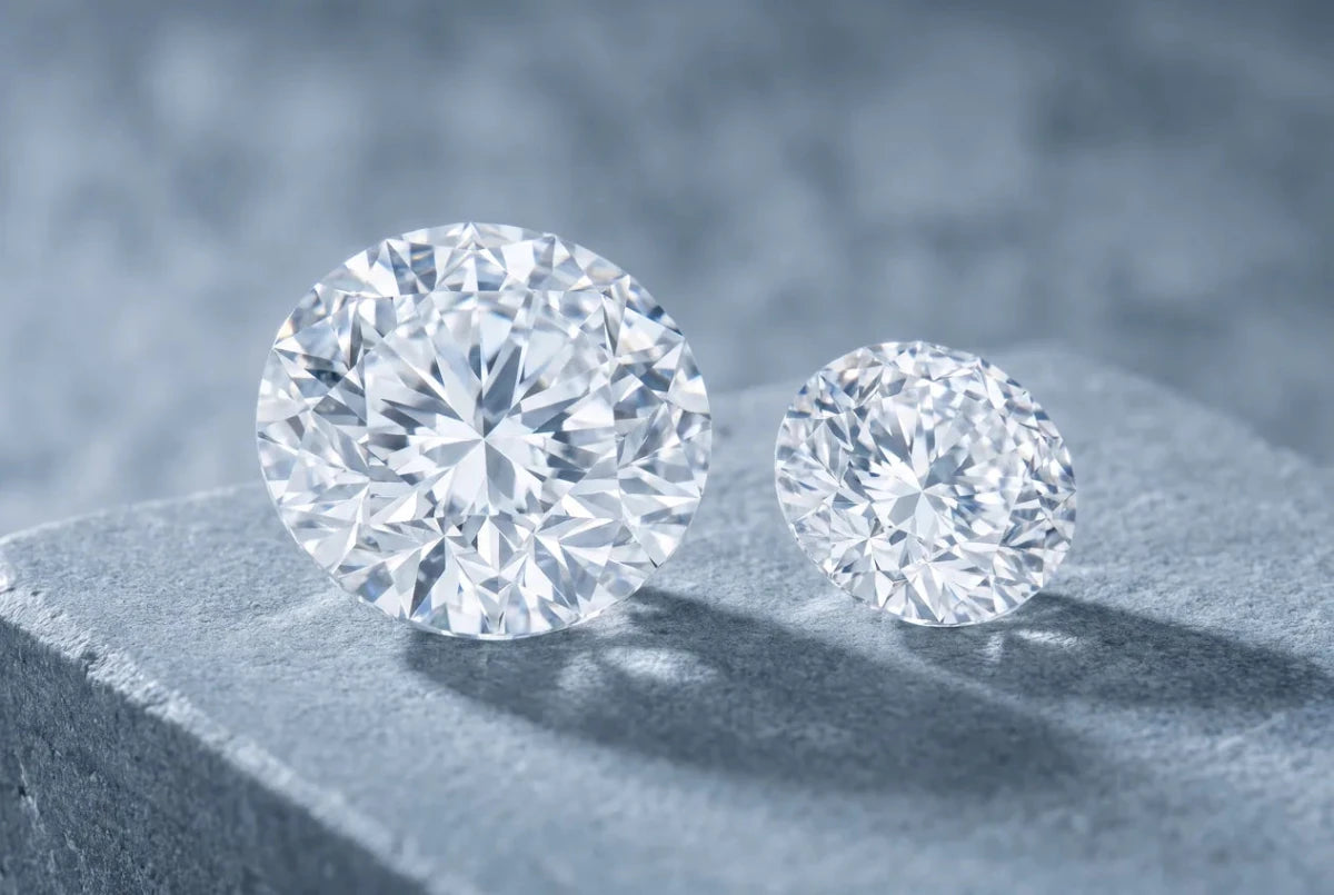 A large round diamond beside a much smaller one, showing the difference in table size