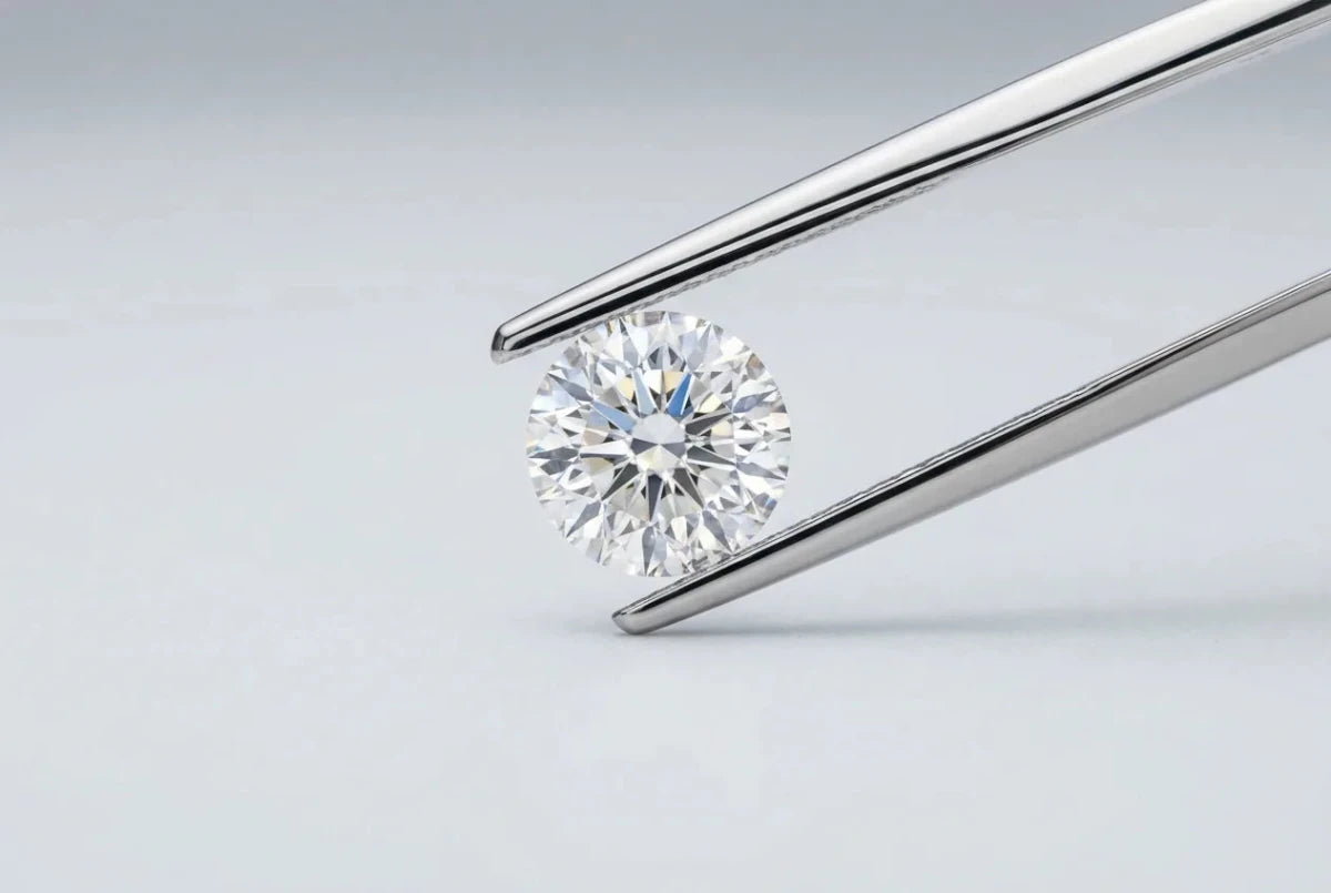 An icy colorless loose diamond held in platinum tweezers
