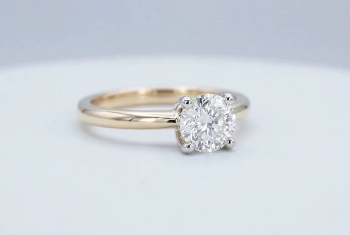 Classic solitaire ring with a single round diamond on a plain band