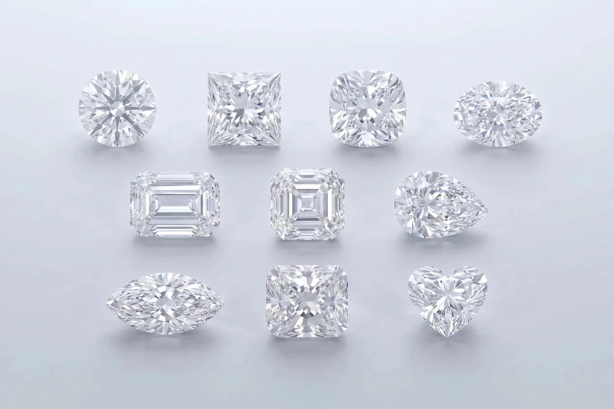 Ten loose diamonds of different shapes arranged in rows on a studio surface