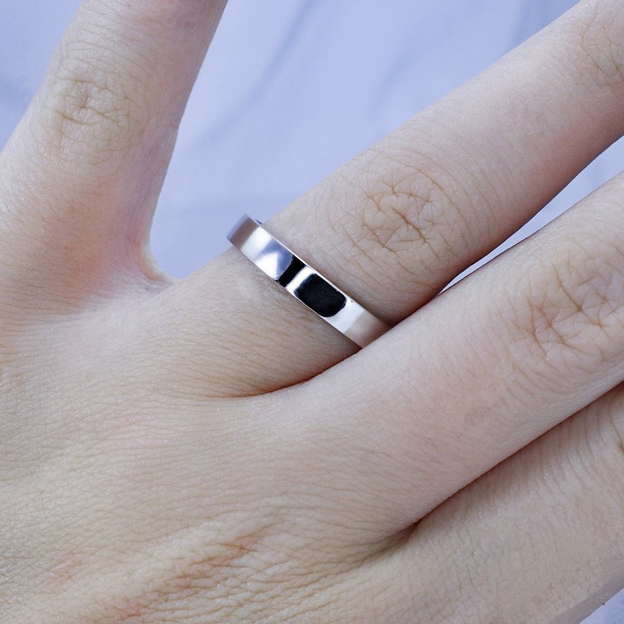 Plain wedding band in 14KT white gold worn on a hand