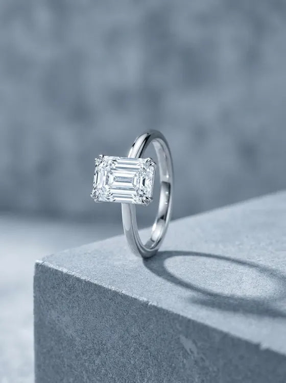White gold solitaire ring with an emerald cut diamond