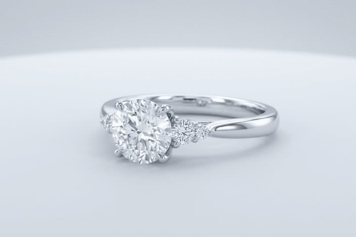 A white gold engagement ring with a round center stone