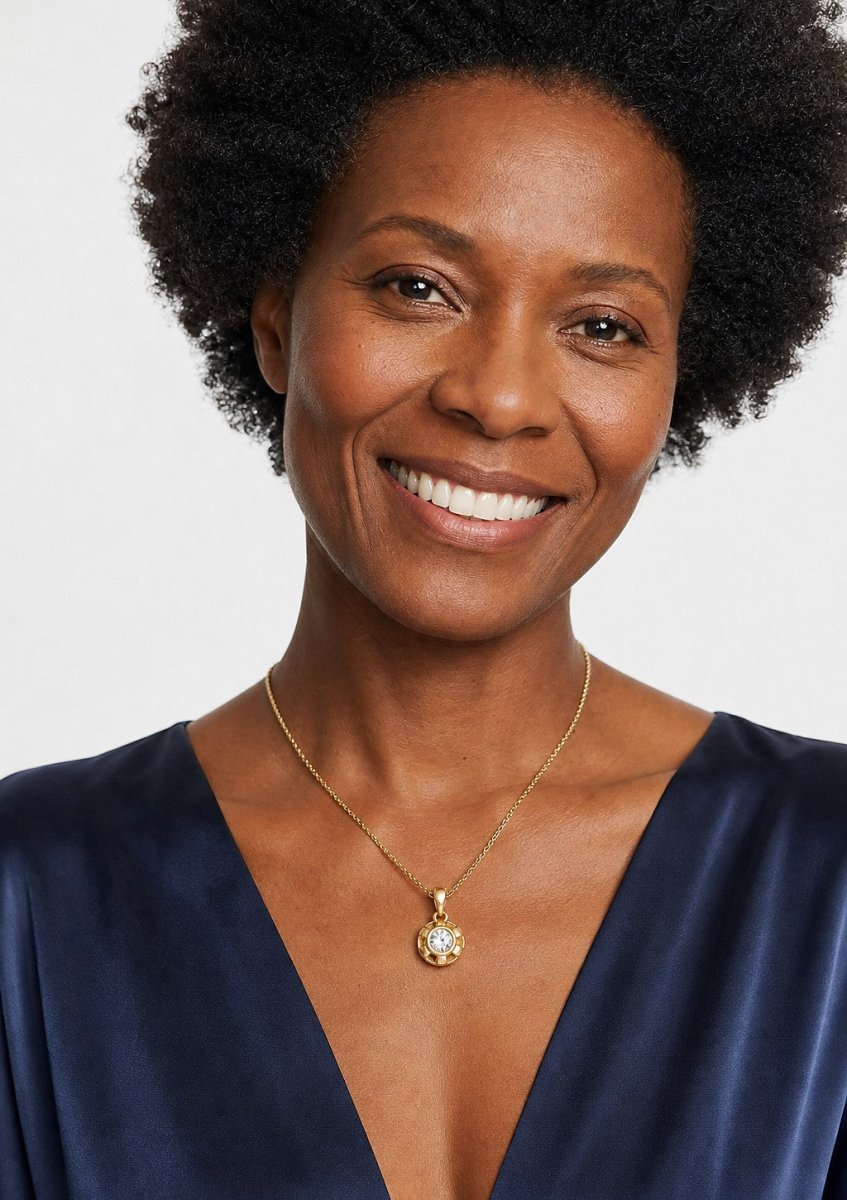 A smiling woman wearing a yellow gold pendant set with heart shaped, with two lobes and a cleft diamonds